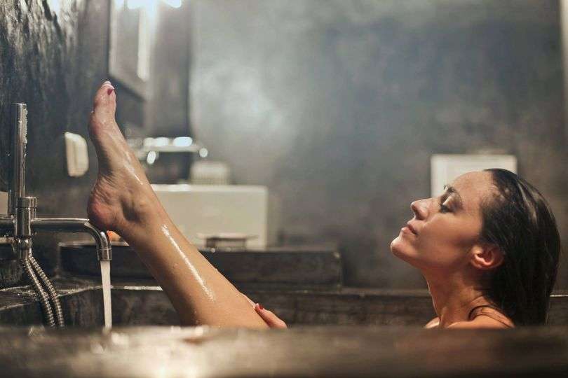 Woman relaxing in a steamy bath.
