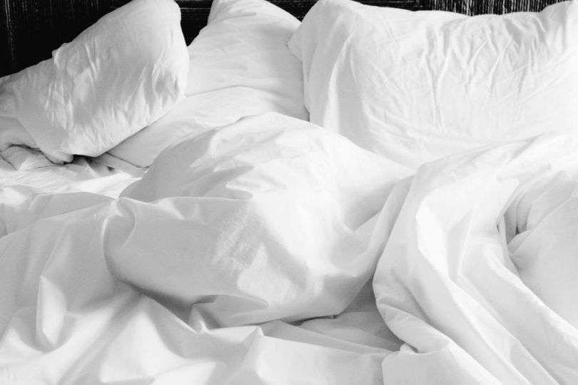 Messy white bedsheets and pillows.