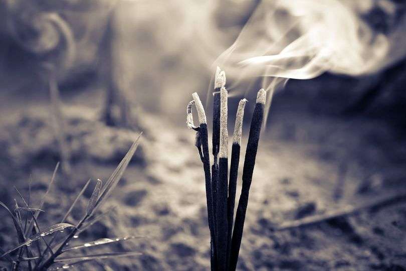 Burning incense sticks releasing smoke.