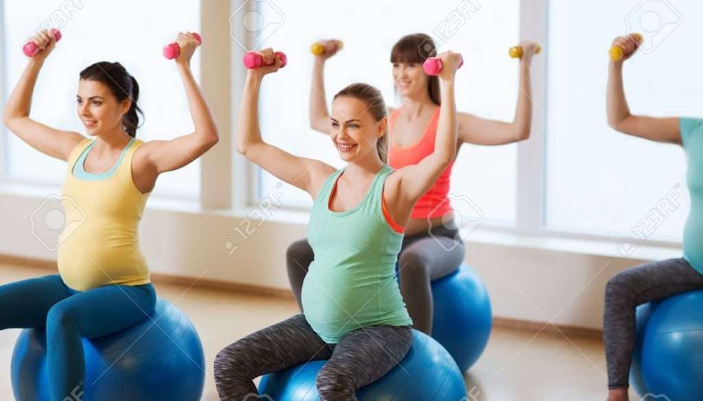 Pregnant women exercising with weights.