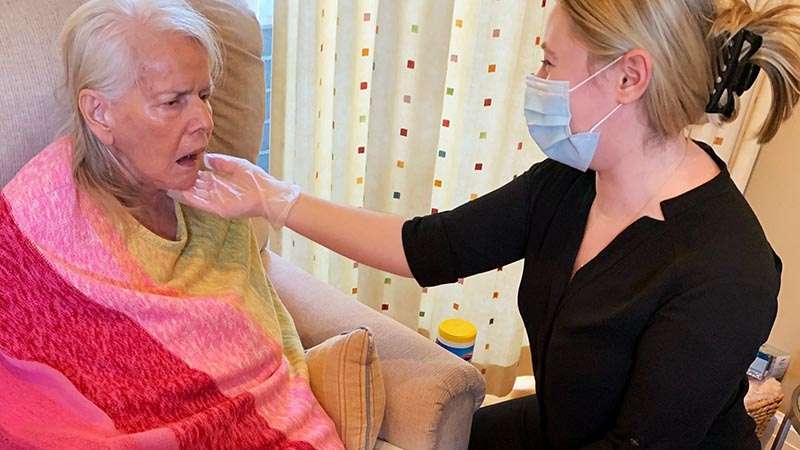 Caregiver assisting elderly woman.