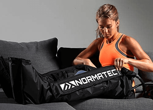 A woman sitting on the couch with her arms in her lap.