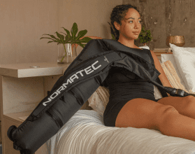 A woman sitting on the bed holding onto a bag